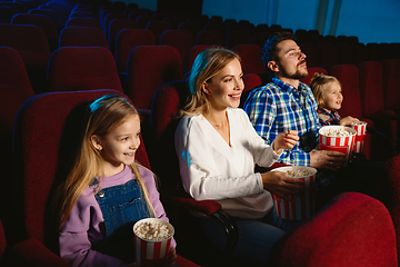 Image showing Young caucasian family watching a film at a movie theater