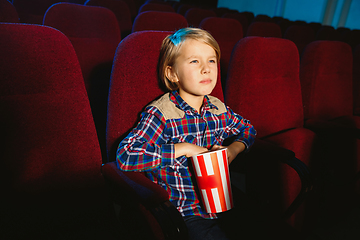 Image showing Little boy watching a film at a movie theater