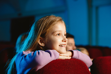 Image showing Young caucasian family watching a film at a movie theater