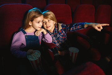 Image showing Little girl and boy watching a film at a movie theater