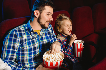 Image showing Young caucasian father and son watching a film at a movie theater