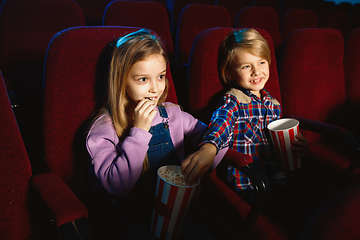 Image showing Little girl and boy watching a film at a movie theater