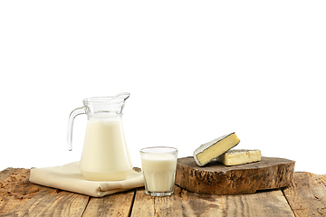 Image showing Different milk products, cheese, cream, milk on wooden table and white background.