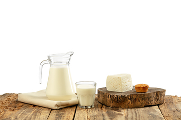 Image showing Different milk products, cheese, cream, milk on wooden table and white background.