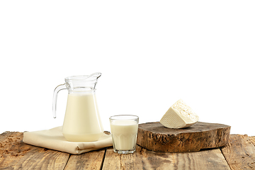 Image showing Different milk products, cheese, cream, milk on wooden table and white background.