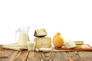 Image showing Different milk products, cheese, cream, milk on wooden table and white background.