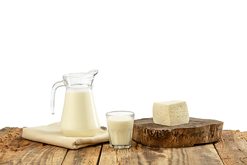 Image showing Different milk products, cheese, cream, milk on wooden table and white background.