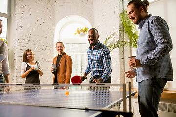 Image showing Young people playing table tennis in workplace, having fun