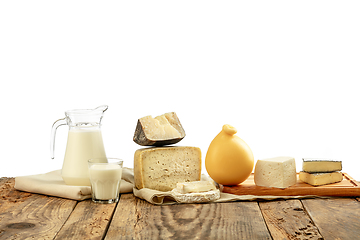 Image showing Different milk products, cheese, cream, milk on wooden table and white background.