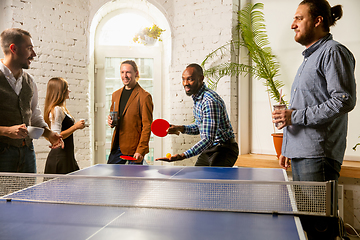 Image showing Young people playing table tennis in workplace, having fun