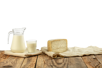 Image showing Different milk products, cheese, cream, milk on wooden table and white background.