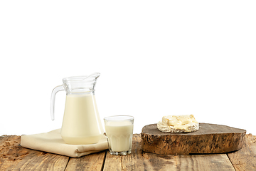 Image showing Different milk products, cheese, cream, milk on wooden table and white background.
