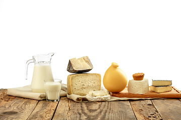 Image showing Different milk products, cheese, cream, milk on wooden table and white background.