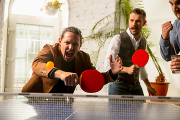 Image showing Young people playing table tennis in workplace, having fun