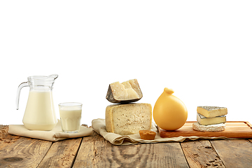 Image showing Different milk products, cheese, cream, milk on wooden table and white background.