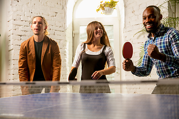 Image showing Young people playing table tennis in workplace, having fun