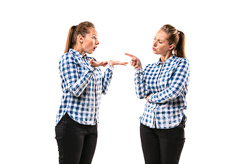 Image showing Young handsome woman arguing with herself on white studio background.