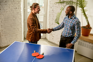 Image showing Young men playing table tennis in workplace, having fun