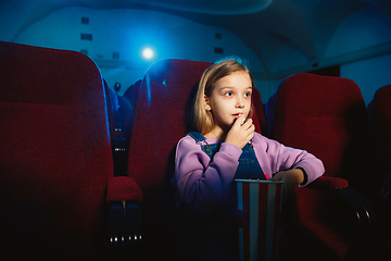 Image showing Little girl watching a film at a movie theater