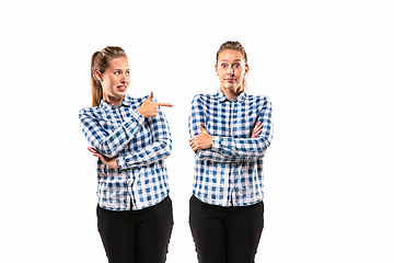 Image showing Young handsome woman arguing with herself on white studio background.