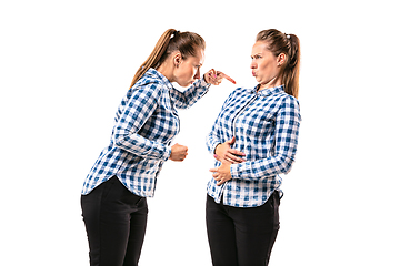 Image showing Young handsome woman arguing with herself on white studio background.