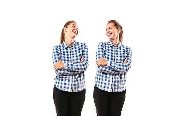 Image showing Young handsome woman arguing with herself on white studio background.