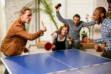 Image showing Young people playing table tennis in workplace, having fun