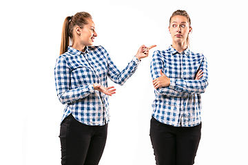 Image showing Young handsome woman arguing with herself on white studio background.