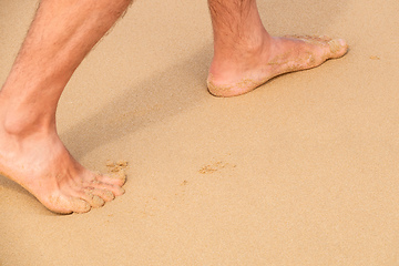 Image showing male bare feet in the wet sand