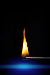 Image showing match stick flame in front of a black background