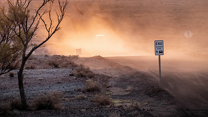 Image showing car on a dusty unsealed road in sunset light mood