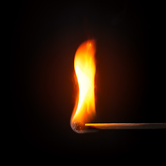 Image showing match stick flame in front of a black background