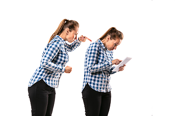 Image showing Young handsome woman arguing with herself on white studio background.