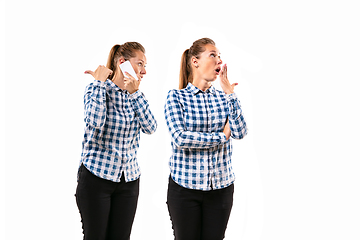 Image showing Young handsome woman arguing with herself on white studio background.