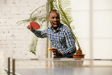 Image showing Young man playing table tennis in workplace, having fun