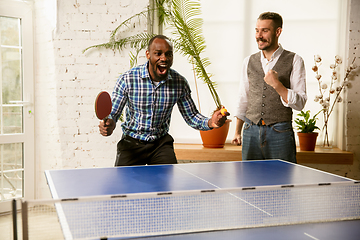 Image showing Young men playing table tennis in workplace, having fun