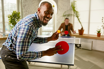 Image showing Young men playing table tennis in workplace, having fun