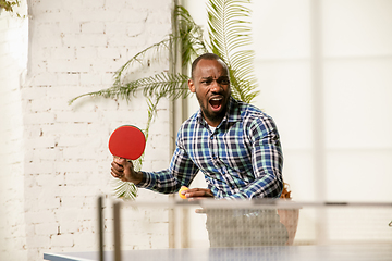 Image showing Young man playing table tennis in workplace, having fun