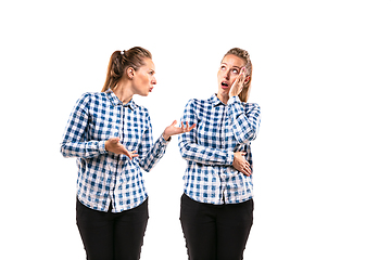 Image showing Young handsome woman arguing with herself on white studio background.