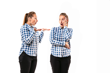 Image showing Young handsome woman arguing with herself on white studio background.