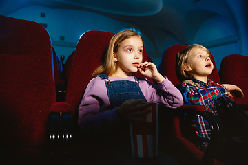 Image showing Little girl and boy watching a film at a movie theater