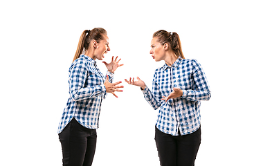 Image showing Young handsome woman arguing with herself on white studio background.