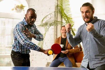 Image showing Young people playing table tennis in workplace, having fun