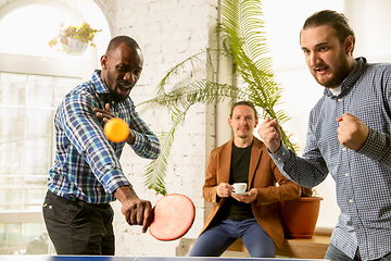 Image showing Young people playing table tennis in workplace, having fun