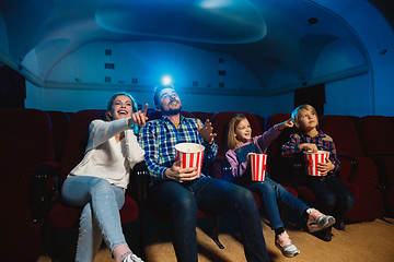 Image showing Young caucasian family watching a film at a movie theater