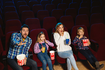 Image showing Young caucasian family watching a film at a movie theater