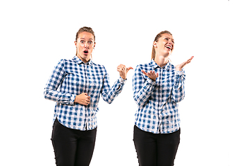 Image showing Young handsome woman arguing with herself on white studio background.