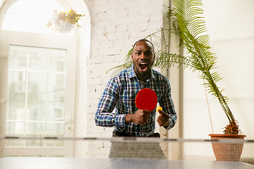 Image showing Young man playing table tennis in workplace, having fun