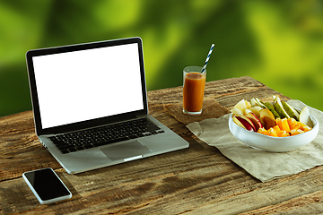 Image showing Blank laptop on a wooden table outdoors, mock up