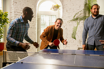 Image showing Young people playing table tennis in workplace, having fun